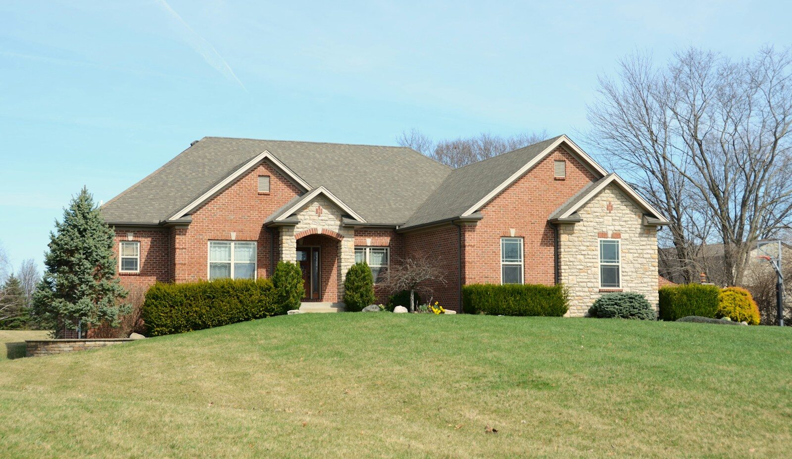 A large brick house with a manicured lawn